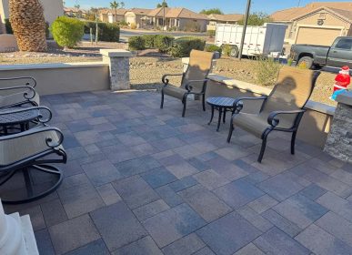 A patio featuring several chairs arranged around a table, set for outdoor relaxation and dining.