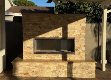 A brick fireplace in a backyard, surrounded by a patio area, ideal for outdoor gatherings and relaxation.